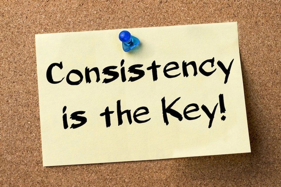 Consistency is the key, written on a post-it note